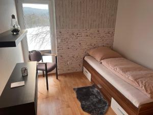 a small bedroom with a bed and a window at Ferienwohnungen Im Hirschgrund in Frohnhausen