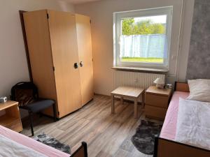 a small bedroom with two beds and a window at Ferienwohnungen Im Hirschgrund in Frohnhausen