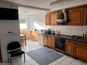 a kitchen with wooden cabinets and a black counter top at Ferienwohnungen Im Hirschgrund in Frohnhausen