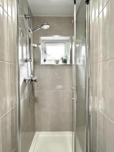 a bathroom with a shower with a tub and a sink at Courtyard Oasis in London