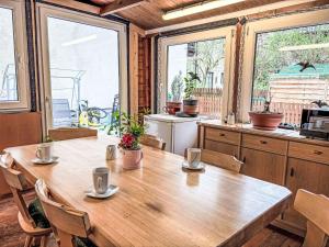 a large wooden table in a kitchen with windows at Apartment Schachner-2 by Interhome in Saalbach Hinterglemm