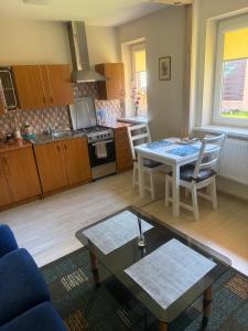 a living room with a table and a kitchen at Palanga Green Hill in Palanga
