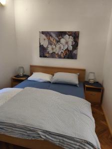 een slaapkamer met twee bedden en een schilderij aan de muur bij Apartma San Marino in Novi Vinodolski
