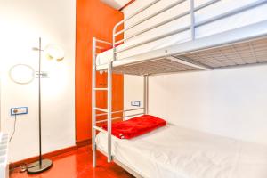 a bunk bed with a red pillow on the bottom bunk at Montroig Mar in Sitges