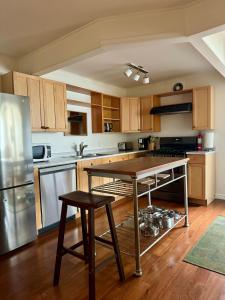 a kitchen with a table and a stainless steel refrigerator at Blue Cypress in Tofino +10 photos