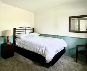 a bedroom with a bed and a mirror and a chair at Blue Cypress in Tofino