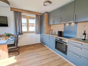 オーバーアウにあるApartment Kragenjoch by Interhomeのキッチン(青いキャビネット、ワイングラス付きのテーブル付) +39枚の写真