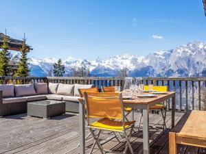 a deck with a table and chairs and a couch at Chalet Chalet Roose by Interhome in Plan Fey