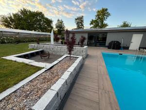 a swimming pool in a yard next to a house at Ferienhaus mit privatem Pool in Soltau