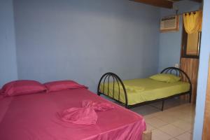 a bedroom with a bed with a pink blanket on it at Il Delfino Pavones in Pavones