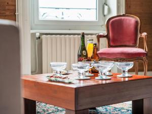 a table with wine glasses and a red chair at Apartment L'écluse-3 by Interhome in Dinard
