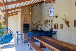 a kitchen with a wooden table and blue chairs at Belíssima casa na praia do Morro Branco in Beberibe