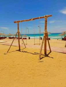 an empty swing set on the beach at استوديو مفروش ومكيف في راس سدر -بحر رملي وحمام سباحة- للعائلات الصغيرة فقط in Ras Sedr