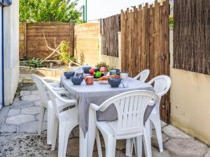 a white table with white chairs and fruit on it at Holiday Home La main d'argent by Interhome in Saint-Méloir-des-Ondes