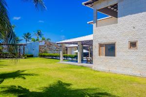 a backyard of a house with a grass yard at Belíssima casa na praia do Morro Branco in Beberibe