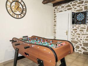 un biliardino in una stanza con un orologio di Holiday Home La Meunière by Interhome a Le Gouray
