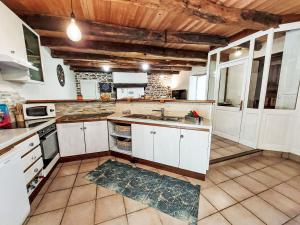 una cucina con mobili bianchi e un lavandino di Holiday Home La Meunière by Interhome a Le Gouray