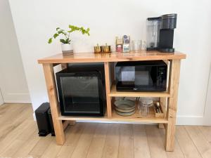 a wooden table with two microwaves on top of it at Posada Nordica - a chic, tranquil mountainview suite in Hope