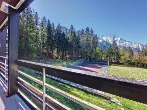 Una vista de un bosque desde un balcón de una casa. en Apartment Résidence Les Tines by Interhome, en Chamonix-Mont-Blanc