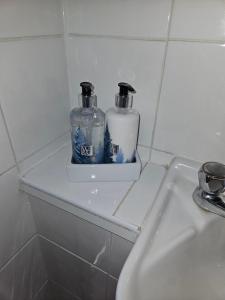 two bottles sitting on a shelf next to a sink at Trillberry Guesthouse in Weymouth +14 photos