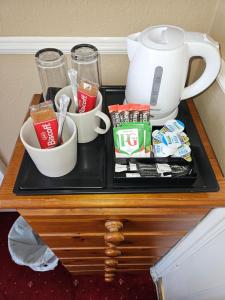 a table with a tea pot and cups on it at Trillberry Guesthouse in Weymouth