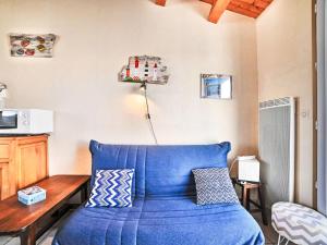 un salon avec un canapé bleu et une table dans l'établissement Holiday Home Les voiliers by Interhome, à Saint-Pierre-dʼOléron