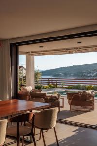 a room with a table and chairs and a large window at Villa Remi in Sumartin