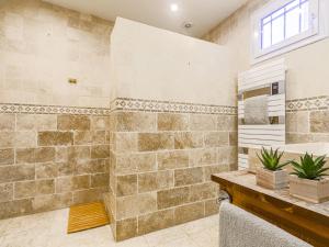 a bathroom with a shower with a stone wall at Holiday Home Villa la Bergerie by Interhome in Nice