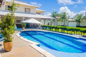 a swimming pool in front of a house at Belíssima casa na praia do Morro Branco in Beberibe