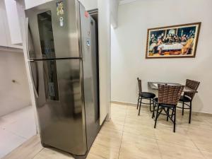 グアルジャにあるR17 · Churrasqueira Privativa, pet friendlyのテーブル付きの客室内のステンレス製冷蔵庫