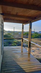 Un porche de madera con vistas a la playa. en Las Fresias, en La Pedrera 13 fotos más