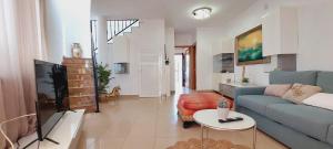 a living room with a blue couch and a table at House with a tropical garden in Adeje