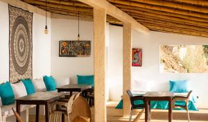 a restaurant with wooden tables and blue chairs at Villa Koté Océan in Toubab Dialaw