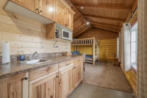 - une cuisine avec des placards en bois et un évier dans une cabine dans l'établissement Ashton Log Cabins, à Ashton