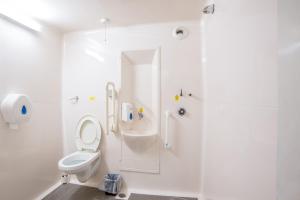 a white bathroom with a toilet and a shower at Metro Inns Teesside in Stockton-on-Tees