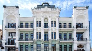 a white building with black windows and balconies at Hotel Zentralnaya in Troitsk