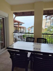 a table and chairs in a room with a balcony at Siviri Blue Horizon Apartment in Siviri