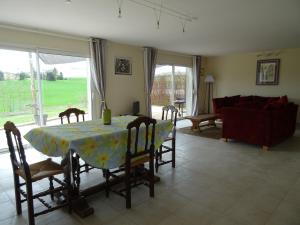 a living room with a table and chairs and a couch at Maison Youkie in Saint-Arailles