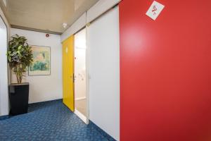 a hallway with a red wall and a red door at Metro Inns Teesside in Stockton-on-Tees