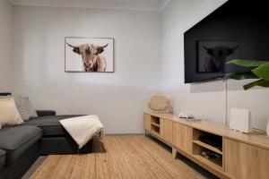 a living room with a couch and a picture of a cow at Beachwood Escape - Dunsborough Private Getaway in Dunsborough