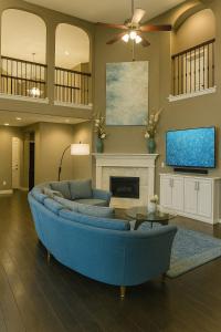 フリスコにあるSpacious 4BR Home in Frisco Ideal for Long Staysの青いソファとテレビのあるリビングルーム