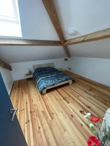 a bedroom with a bed on a wooden floor at Charmante maison typique des Landes in Linxe