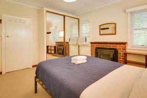a bedroom with a bed and a fireplace at Pebbles by the Bay - Central Busselton in Busselton