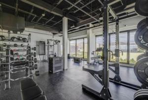 a gym with a large room with equipment and windows at Cityscape Peaks Penthouse DT Gym Free parking in Salt Lake City