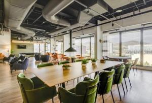 a conference room with a large wooden table and green chairs at Cityscape Peaks Penthouse DT Gym Free parking in Salt Lake City