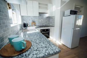 a kitchen with a counter and a white refrigerator at Anzac Hwy near airport, beach in Plympton