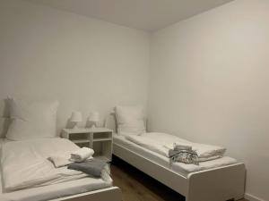 two beds in a room with white walls at Modernes 1-Zimmer Apartment mit 2 Einzelbetten in Offenbach bei Frankfurt in Offenbach
