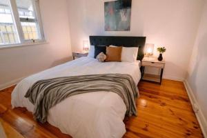 a bedroom with a large bed with a teddy bear on it at 2BR unit at Glenelg Beach in Glenelg