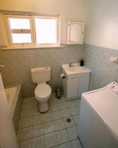 a bathroom with a toilet and a sink at 2BR unit at Glenelg Beach in Glenelg