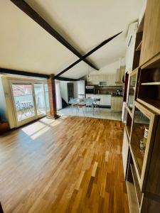 a living room with a wooden floor and a kitchen at Tino'S House 2punto0 in La Spezia